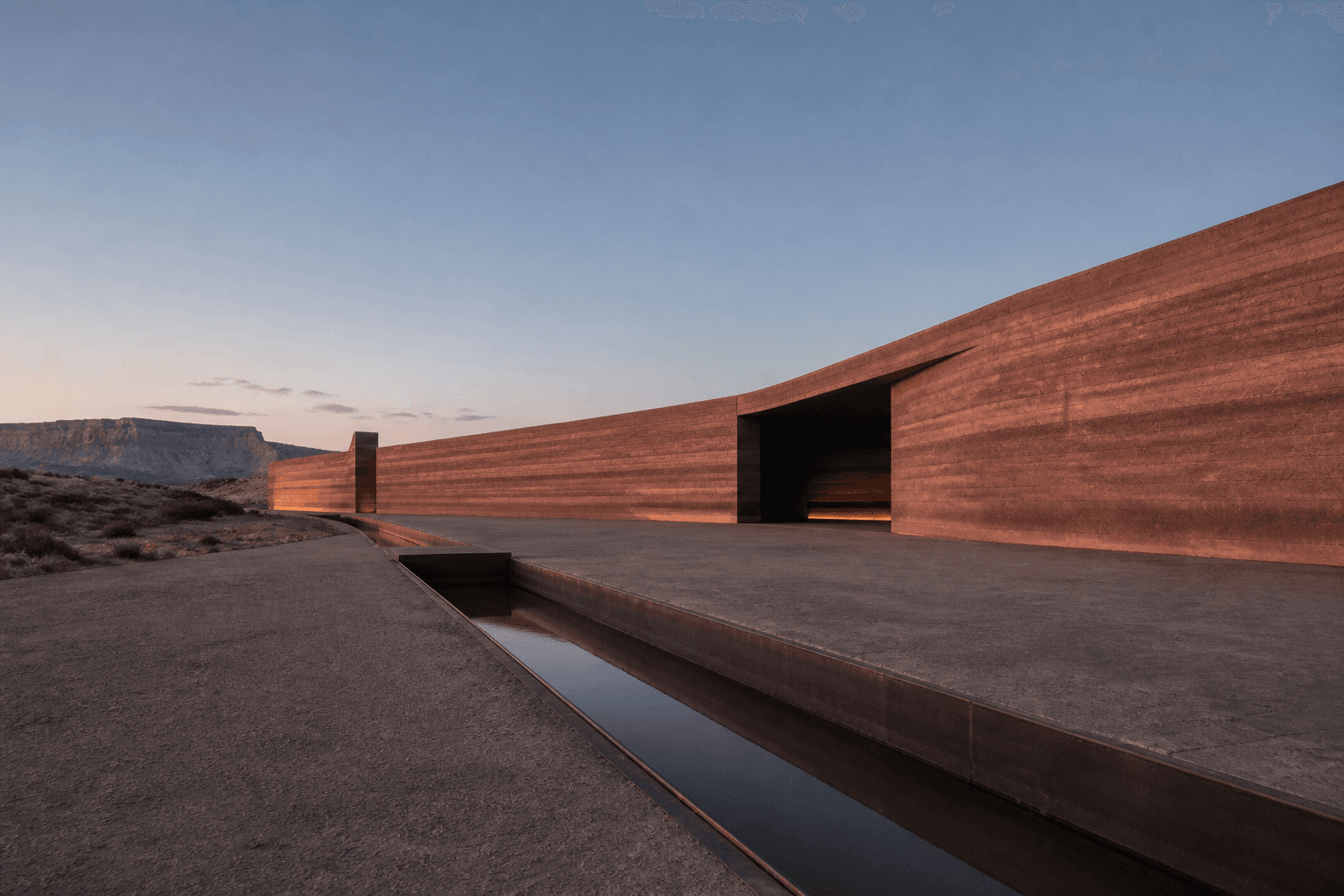 Synthetic concept study: Rammed earth, quiet geometry, and the play of desert light.